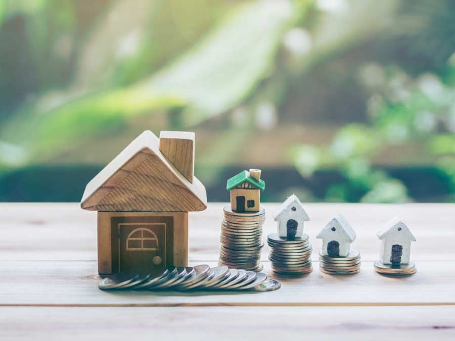 Small wooden block houses on top of piles of coins